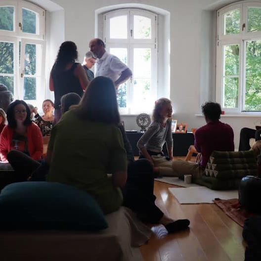 Menschen unterhalten sich sitzend und stehend