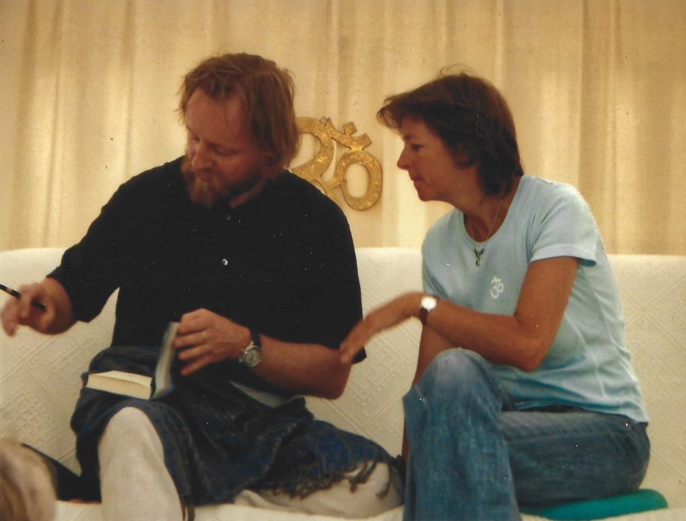 Schülerin neben Lehrer vor OM-Zeichen